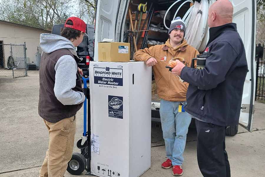 Bear’s Plumbing technicians unloading a water heater for installation in Spring TX