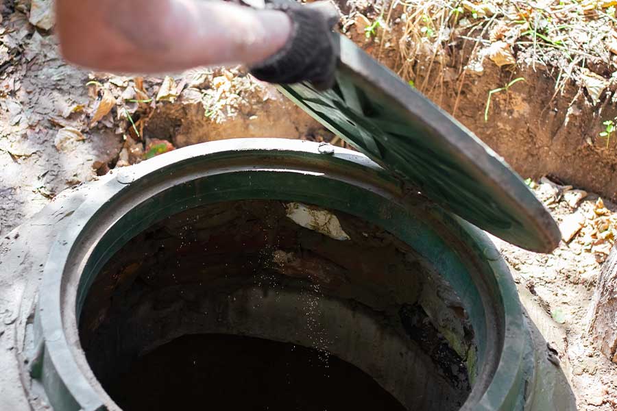 Plumber inpsecting an underground plumbing access point in Conroe, TX